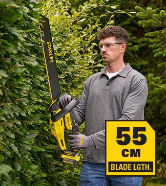 Stanley FatMax V20 STCHT8255 18V Cordless Hedge Trimmer – 55cm Blade Man trimming a tall hedge with the Stanley FatMax V20 STCHT8255 18V cordless hedge trimmer – 55cm blade length