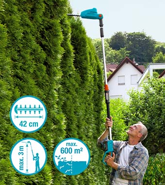 Cut high hedges with little effort
and a secure footing – at heights
of up to three metres, when the
telescopic handle is fully extended
and up to 600 square metres of hedge. Gardener trimming tall hedge with a telescopic hedge trimmer
